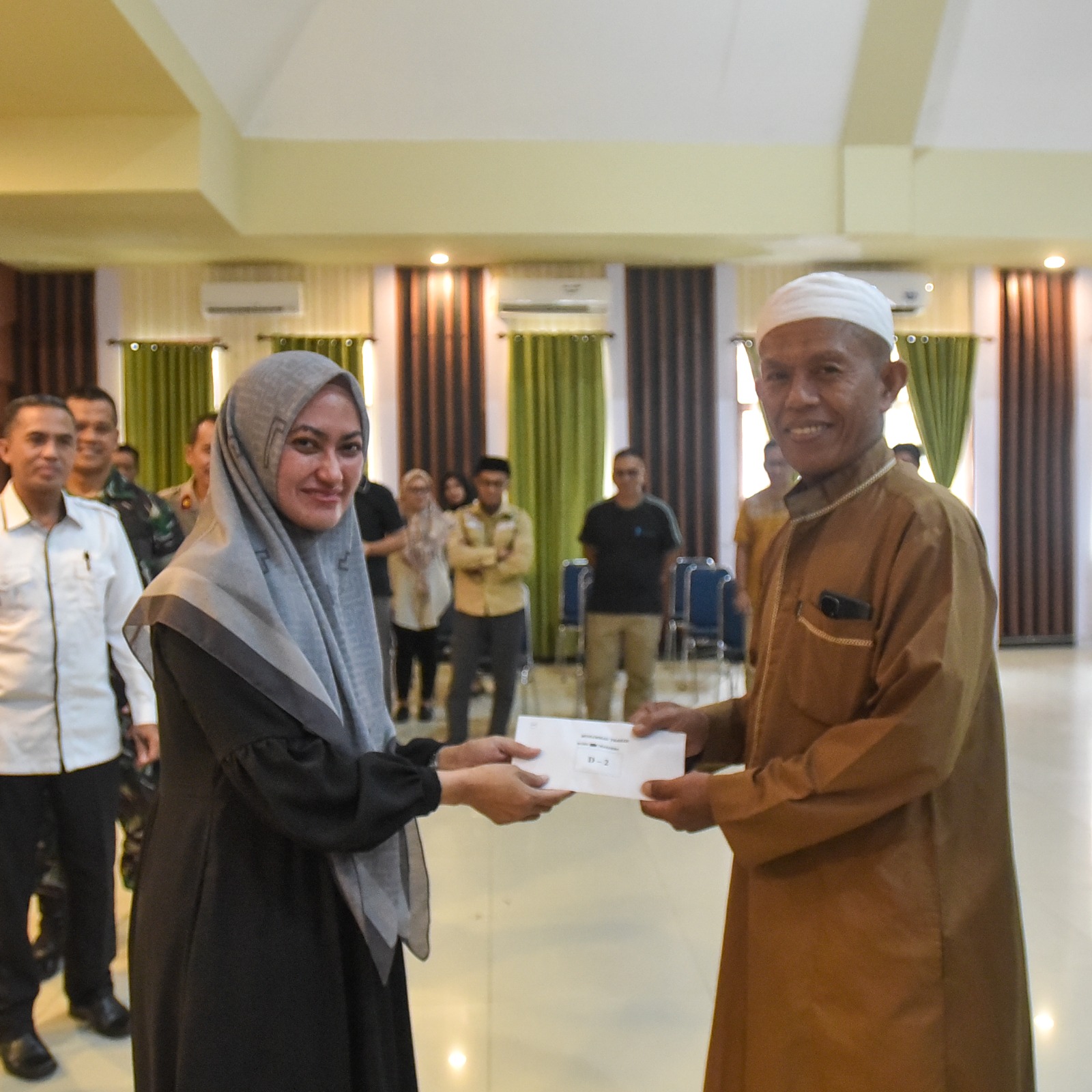 Bupati Luwu Utara Indah Putri Indriani menyerahkan kunci hunian tetap kepada salah satu penyintas banjir bandang. Jumat (30/03/2023)